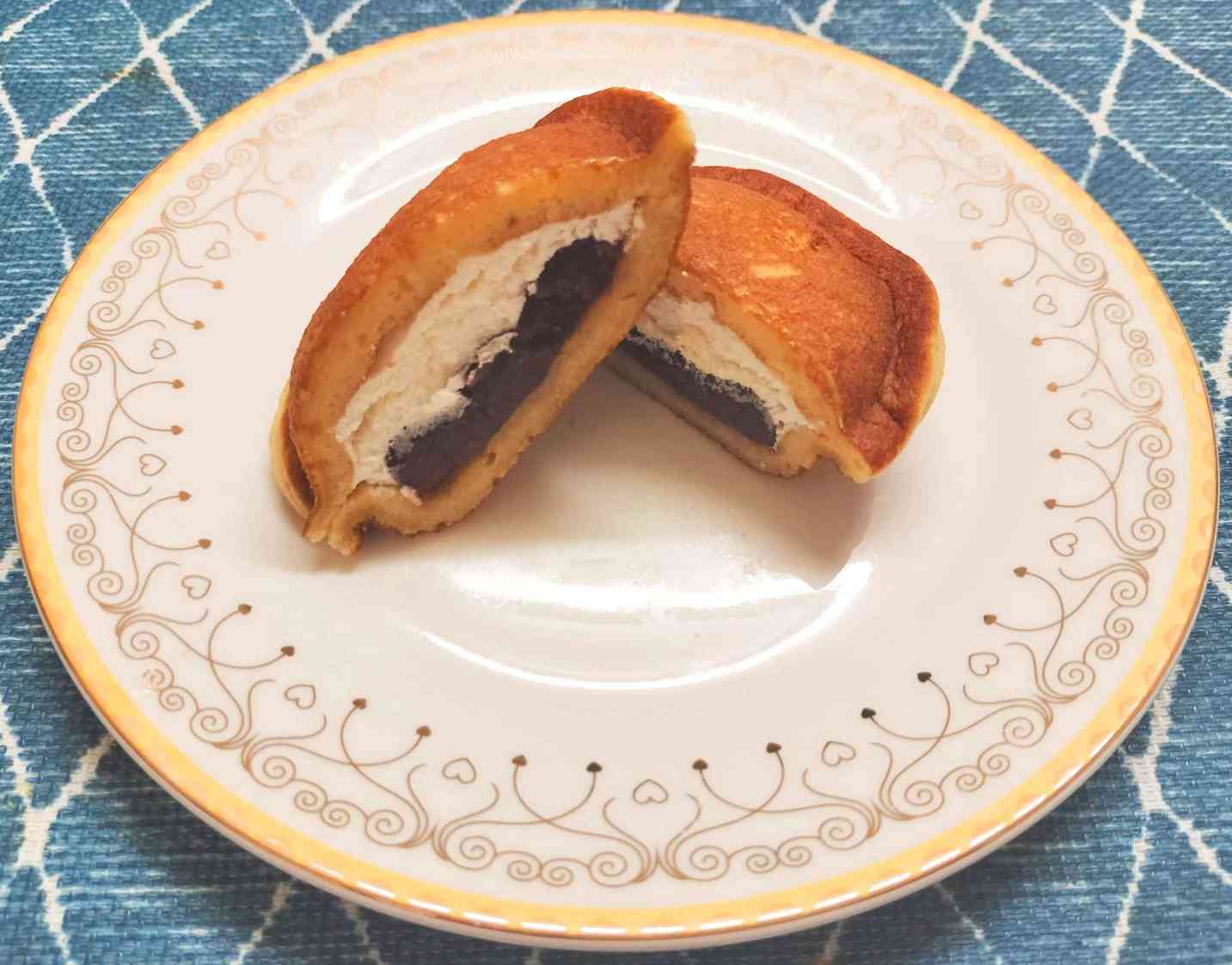 Japanese dorayaki dessert filled with red bean paste and whipped cream on a plate