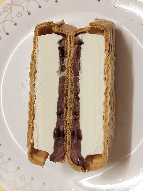 Cross-section of taiyaki monaka ice cream showing azuki red bean filling and vanilla ice cream"